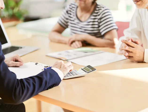 テーブルに座って書類を見ている2人のビジネスパーソン