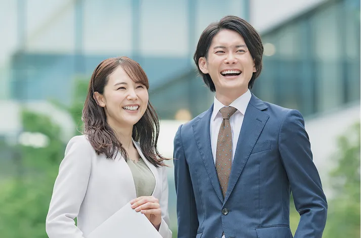 屋外で笑顔で立つ男女のビジネスパーソン